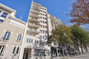 un edificio blanco alto en una calle de la ciudad en Cosy and renovated studio in heart of Paris XVieme, en París