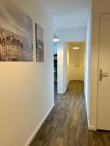 an empty hallway with white walls and wood floors at Jolie chambre 3minutes de la Gare RER A in Bussy-Saint-Georges