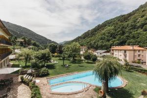 un complejo con piscina y montañas de fondo en Hotel Catalunya Park, en Ribes de Freser