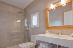 a bathroom with a sink and a toilet and a mirror at Alojamientos Turísticos Cardona - Estudio Doble Superior in Es Pujols