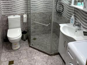 a bathroom with a shower and a toilet and a sink at Angel Apartment in Porta Batumi in Batumi