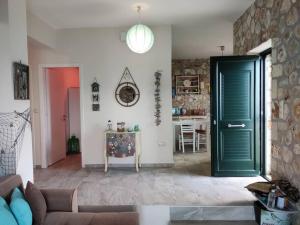 a living room with a green door and a table at Korina's house in Loutsa +39 photos