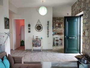 a living room with a green door and a table at Korina's house in Loutsa
