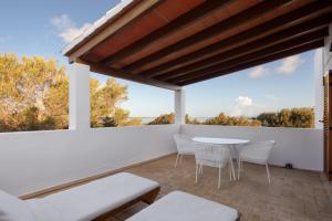 a patio with a table and chairs and a large window at Alojamientos Turísticos Cardona - Estudio Doble Superior in Es Pujols