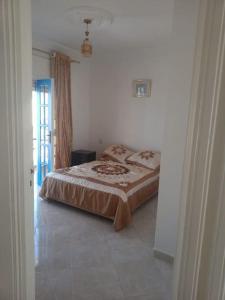 um quarto com uma cama num quarto branco em Villa Mama Swiriya Atlantique em Souira Guedima