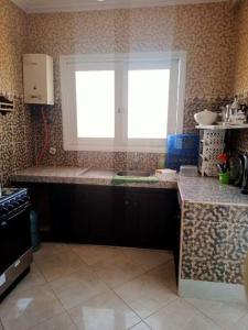uma cozinha com um lavatório e uma janela em Villa Mama Swiriya Atlantique em Souira Guedima