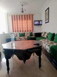 a living room with a couch and a coffee table at Villa Mama Swiriya Atlantique in Souira Guedima