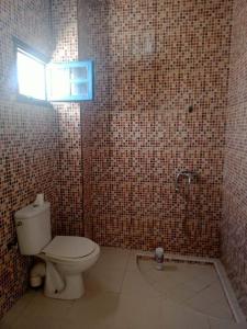 a bathroom with a toilet and a window at Villa Mama Swiriya Atlantique in Souira Guedima