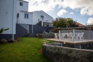 a yard with a white bench and a house at Oásis Fonte Grande in Santo António