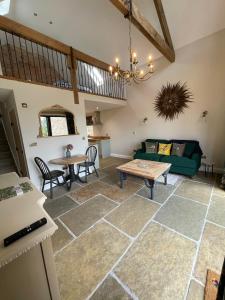 a living room with a green couch and a table at Converted Bullamoor Barns, Northallerton in Northallerton