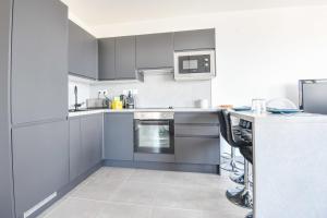 een keuken met grijze kasten en een aanrecht bij Le Ruffi - Appart 1 ch avec terrasse et parking in Marseille