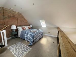 1 dormitorio con cama y pared de ladrillo en Converted Bullamoor Barns, Northallerton en Northallerton