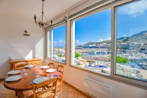 a dining room with a table and a large window at Le Cabanon des Goudes - Vue mer et parking in Marseille