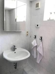 Baño blanco con lavabo y espejo en Schöne Wohnung für einen Kurzurlaub in Lüneburg, en Lüneburg