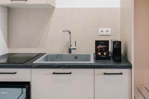 a kitchen counter with a sink and a coffee maker at Noa Suites in Arillas