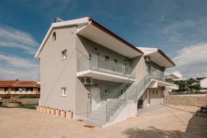 a white building with stairs on the side of it at Noa Suites in Arillas