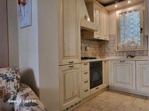 a kitchen with white cabinets and a stove at Queen House in Montopoli in Val dʼArno