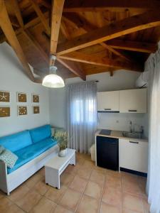 a living room with a blue couch and a kitchen at Alexander Apartments in Skala Kefalonias