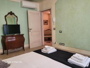 a room with a bed and a tv and a mirror at Queen House in Montopoli in Val dʼArno