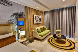 a living room with a couch and a chair and a television at ZIMBALI BOULEVARD SUIT 260 in Ballito
