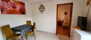 a dining room with a table and chairs and a television at Apartment Mužić in Cres