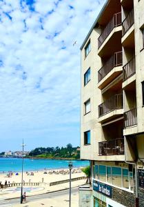 un edificio junto a una playa con gente en él en Apartamentos JL&DN Primera Línea Playa Silgar *Sansenxo*, en Sanxenxo