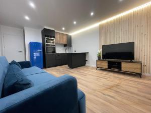 een woonkamer met een bank en een flatscreen-tv bij Apartamentos JL&DN Primera Línea Playa Silgar *Sansenxo* in Sanxenxo