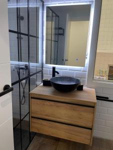 y baño con lavabo negro y ducha. en Apartamentos JL&DN Primera Línea Playa Silgar *Sansenxo*, en Sanxenxo