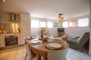 une cuisine et un salon avec une table et un canapé dans l'établissement Essey-St Bohème 6 pers parking apt en souplex, à Essey-lès-Nancy 12 autres photos