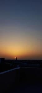 una puesta de sol en el cielo con el sol en la distancia en Dar lbhar, en Kelibia