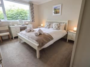 a bedroom with a bed and a desk and a window at Silver Birches in Windermere
