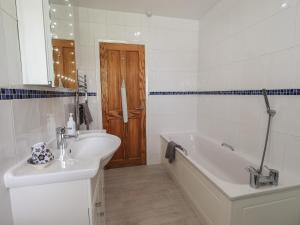 a bathroom with a tub and a sink and a bath tub at Silver Birches in Windermere +23 photos