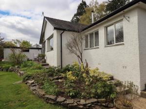 a white house with a stone retaining yard at Silver Birches in Windermere