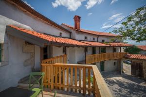 une maison avec une terrasse couverte en bois et une terrasse dans l'établissement Karst Heritage Retreat, à Štanjel
