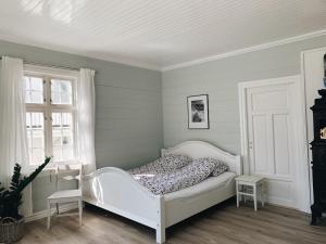 um quarto com uma cama branca e uma janela em Valldal Sentrum Overnatting em Valldal