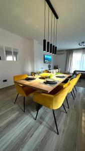 comedor con mesa y sillas amarillas en Magnolia Apartment Zadar, en Zadar
