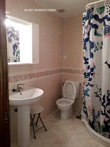 a bathroom with a sink and a toilet and a shower curtain at Piso al lado de la estación de tren y de la playa, con dos plazas de garage in Vilagarcia de Arousa +5 photos