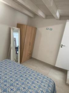 a bedroom with a bed and a wooden door at appartamento francy solare in Castellammare del Golfo