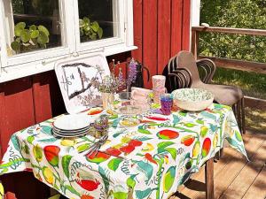 uma mesa com uma toalha de mesa num alpendre com pratos e tigelas em Holiday home Bottnaryd II em Bottnaryd