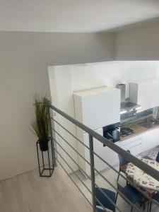 a room with a kitchen and a staircase with a potted plant at appartamento francy solare in Castellammare del Golfo