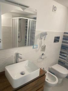 a bathroom with a sink and a toilet and a mirror at appartamento francy solare in Castellammare del Golfo