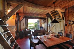 a dining room and living room with a wooden table at De Schaapskooi in Hezingen