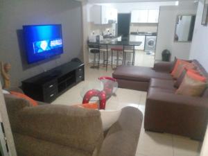 a living room with a couch and a tv at Sandz accomodation at 108 in Durban