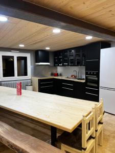 Il comprend une cuisine équipée d'une table en bois et d'un réfrigérateur blanc. dans l'établissement Gîte BB OURS, à Villard-de-Lans