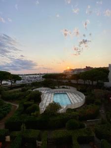 uitzicht op een tuin met een zwembad bij STUDIO VUE PORT PISCINE PARKING in Cap d'Agde