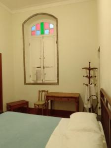 una camera con letto e finestra istoriata di Hotel Bragança a Caxambu