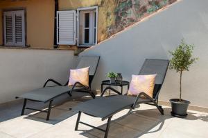 dwa krzesła i stół na patio w obiekcie Old Town Rooms Piran w mieście Piran