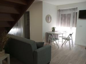 een woonkamer met een tafel en een stoel bij Apartamentos "El Balconico" in Arguedas