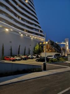 a parking lot with cars parked in front of a large building at Beach Pearl in Bečići