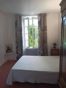 - une chambre avec un grand lit et une fenêtre dans l'établissement Maison de la Rivière, à Clamecy